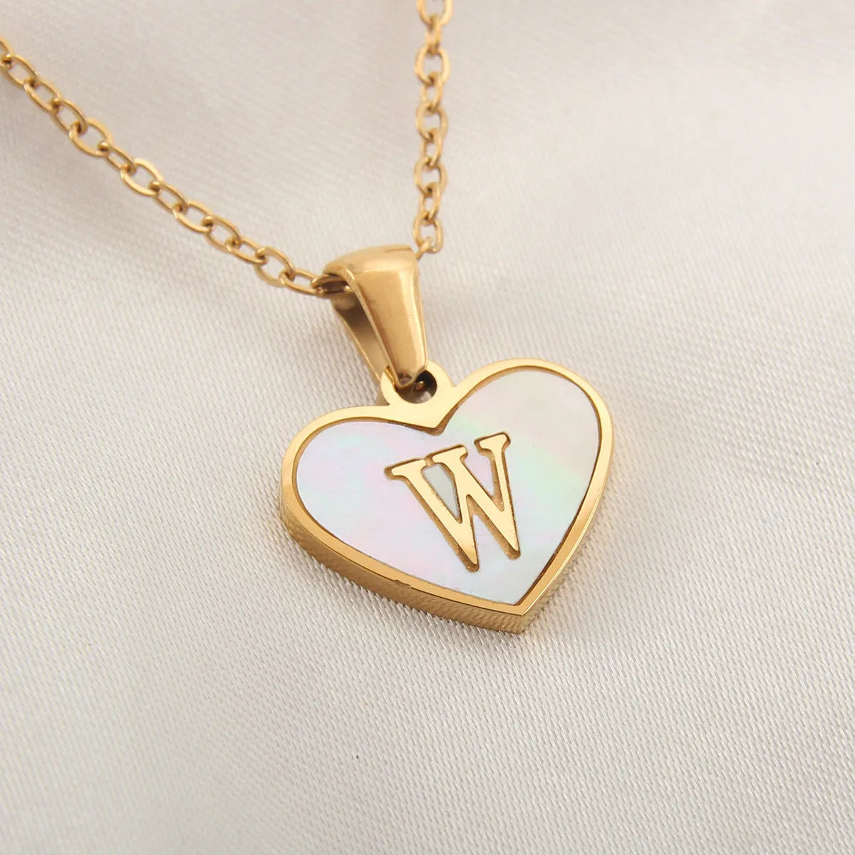 Gold-plated heart necklace with white shell pendant showing letter personalisation option