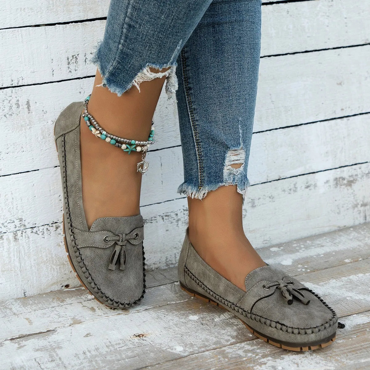 Women's solid-colour suede flat shoes with a bow on the front, shown in apricot colour.