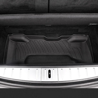 Custom black rubber floor mats fitted in a Tesla Model 3, showing deep grooves and raised edges.