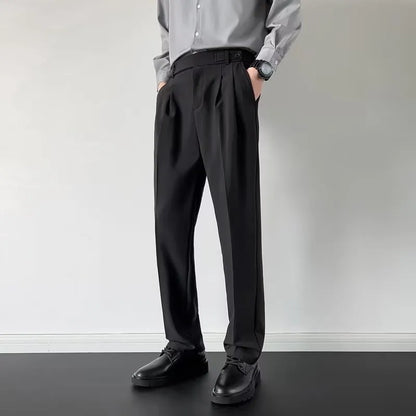 Men's apricot and black straight-leg loose-fit trousers laid flat, showing waistband and full leg.