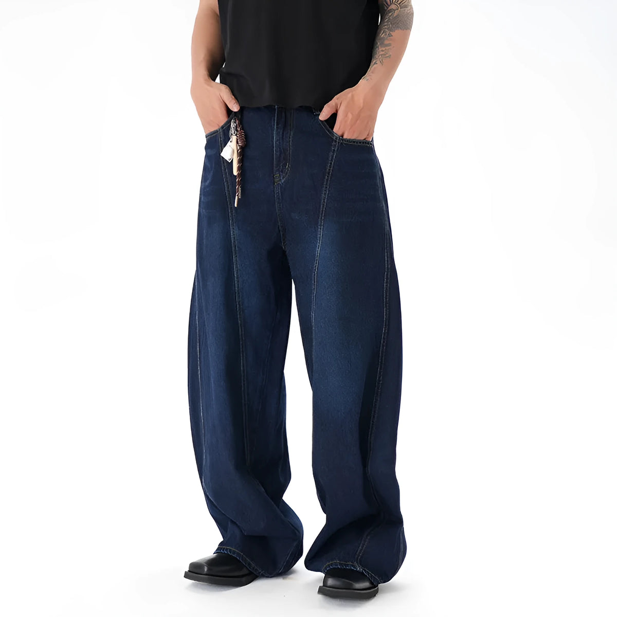 Dark blue distressed wide leg Machete jeans laid flat, showing washed denim texture.