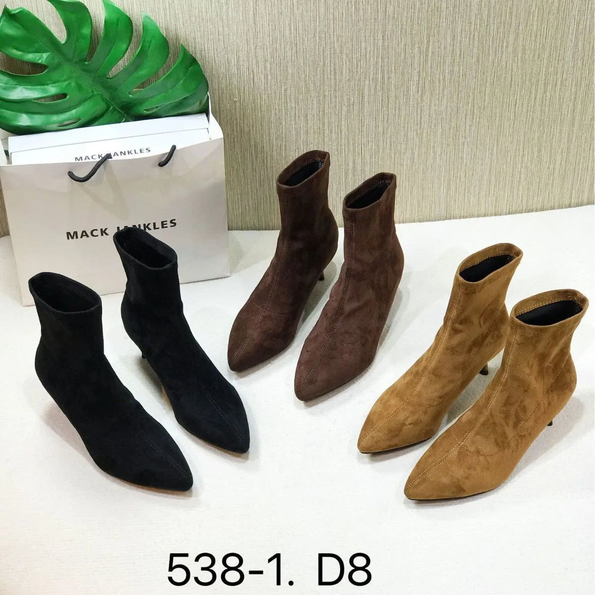 Women's black pointed toe ankle boots with a stiletto heel on a neutral background