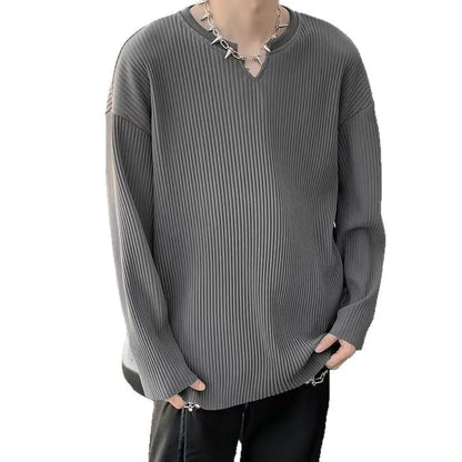 A woman wearing a black and white striped, loose-fit, long-sleeve pullover jumper.