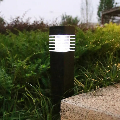 A tall, cuboid-shaped white solar lawn lamp standing in a garden.
