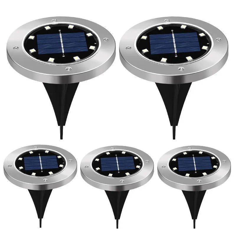 Stainless steel solar garden ground lamp installed in a lawn.