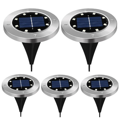 Stainless steel solar garden ground lamp installed in a lawn.