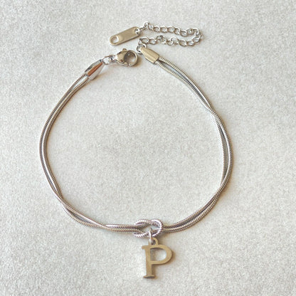 Elegant letter charm bracelets for women in gold and silver tones, featuring a delicate snake chain design and personalised letter charms.