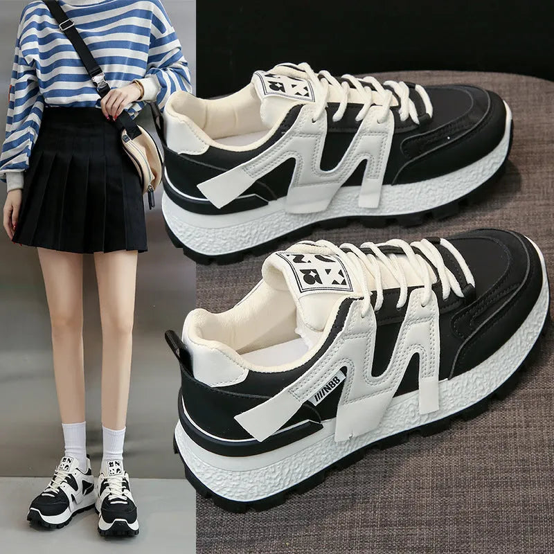 Low-top casual sneakers in black and white with rubber soles and lace-up front closure