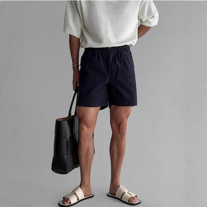 Cotton loose-fit sports shorts in black, shown on a hanger.