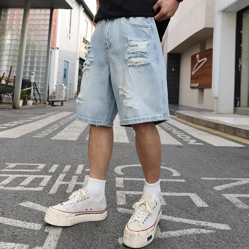 Light blue distressed denim shorts with rips and loose straight fit on mannequin