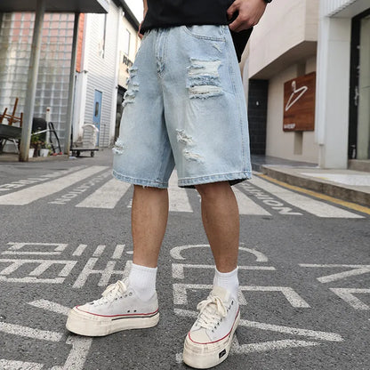 Light blue distressed denim shorts with rips and loose straight fit on mannequin