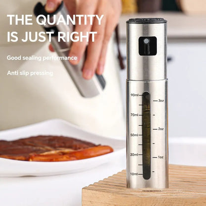 Glass oil spray bottle with stainless steel press cap showing 100ml capacity