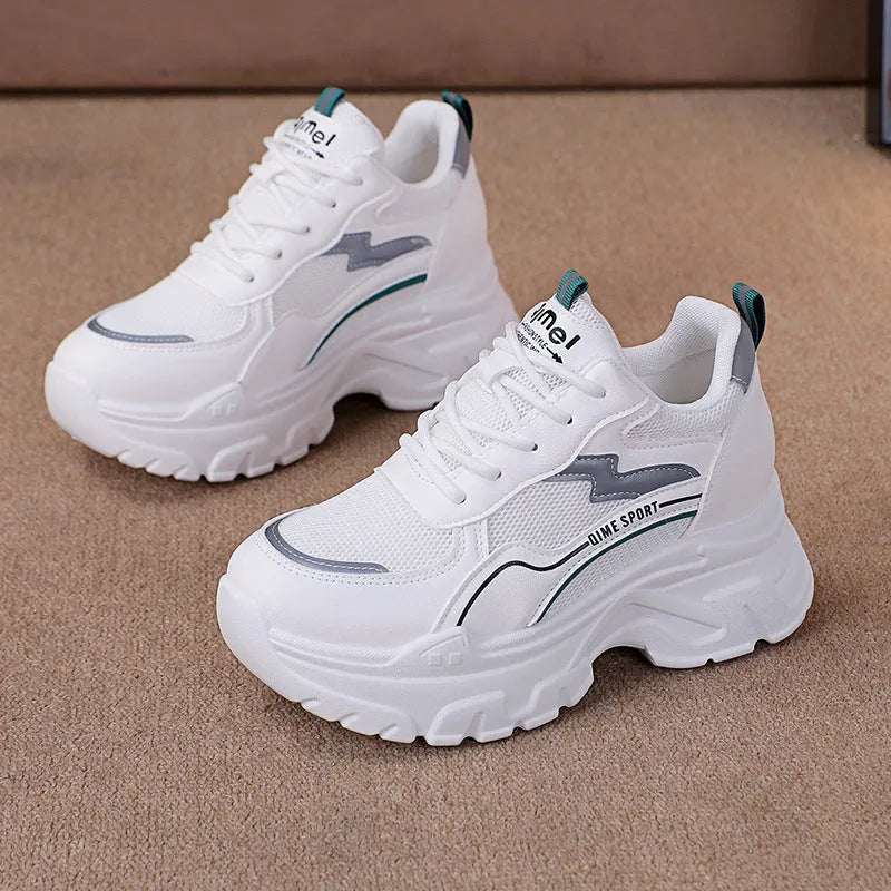 White women's dad sports trainers with cross straps and a lace-up front on a rubber sole.