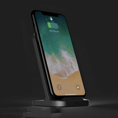 Dark grey vertical aluminium wireless charging stand for iPhone on a desk