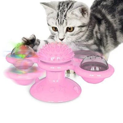 Cat playing with rotating windmill toy featuring luminous balls and suction base
