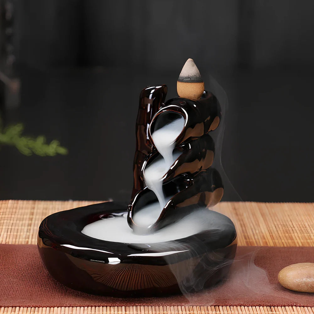 Black ceramic backflow incense burner creating waterfall smoke with sandalwood aroma
