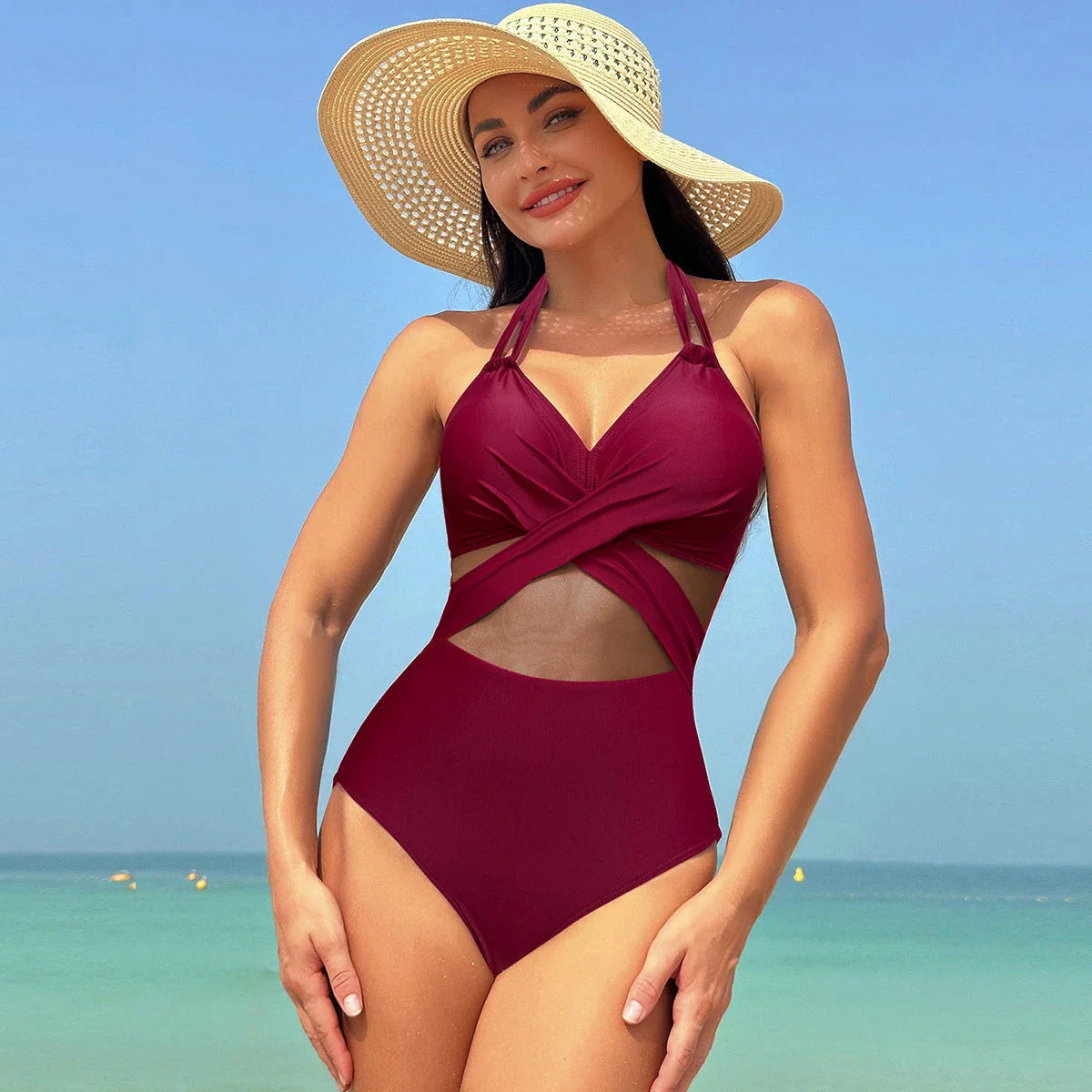 One-piece swimsuit with halter-neck and cross-strap design, available in various solid colors and a leopard print pattern