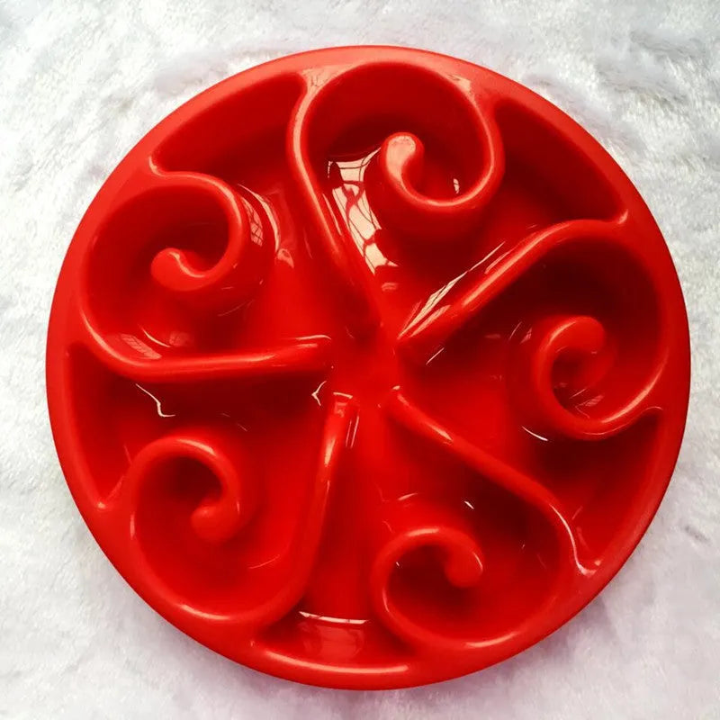 Coloured plastic dog slow feeder bowl showing internal maze pattern and ridges, with wide non-slip base