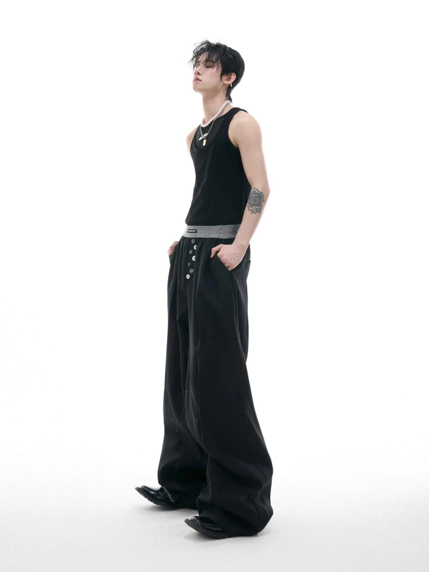 Straight-leg trousers with button-open line detail in black and grey colours, showing high-waist design and tailored silhouette