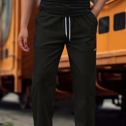 Men's light grey polyester trousers with an elasticated waistband laid flat