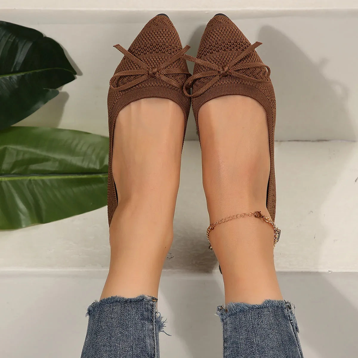 Women's blue knitted loafer flat shoes with a pointed toe and decorative bow detail on the front.