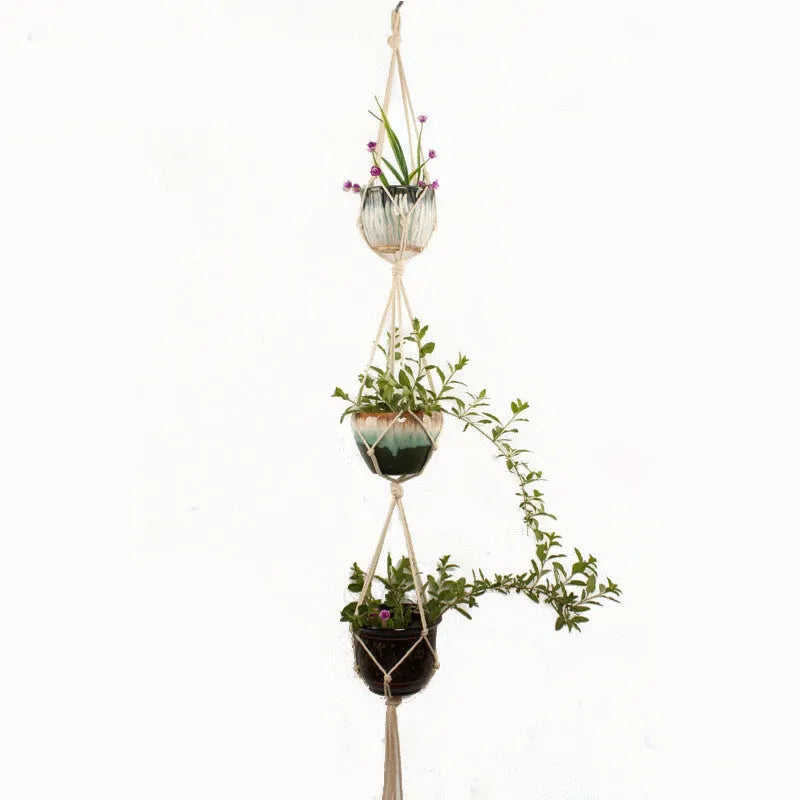 Handwoven natural cotton rope plant hanger cradling a green potted succulent on a wooden table.