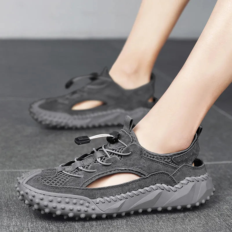 Men's black waterproof wading sandals with elastic band and perforated leather mesh upper on a rubber sole.