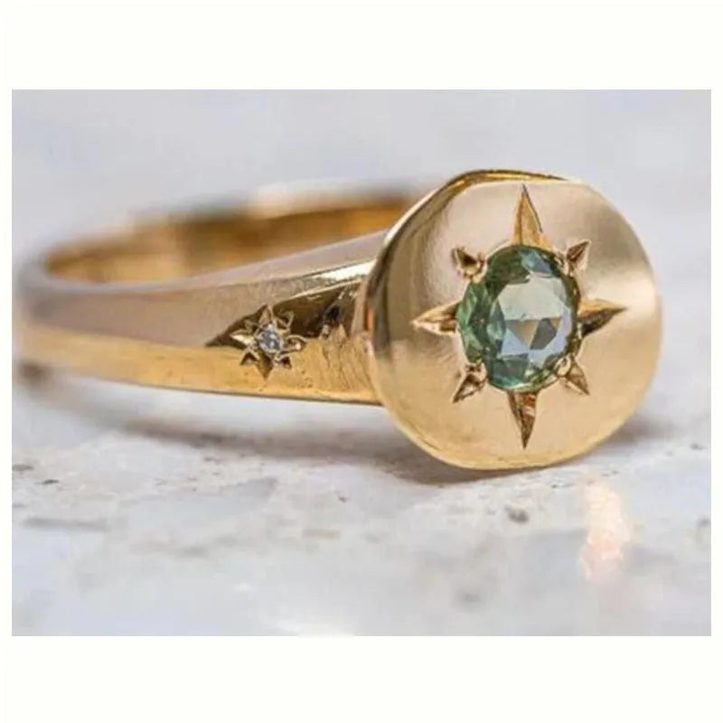 Golden ring with oval asterism zircon, star shape, and adjustable opening on a plain background
