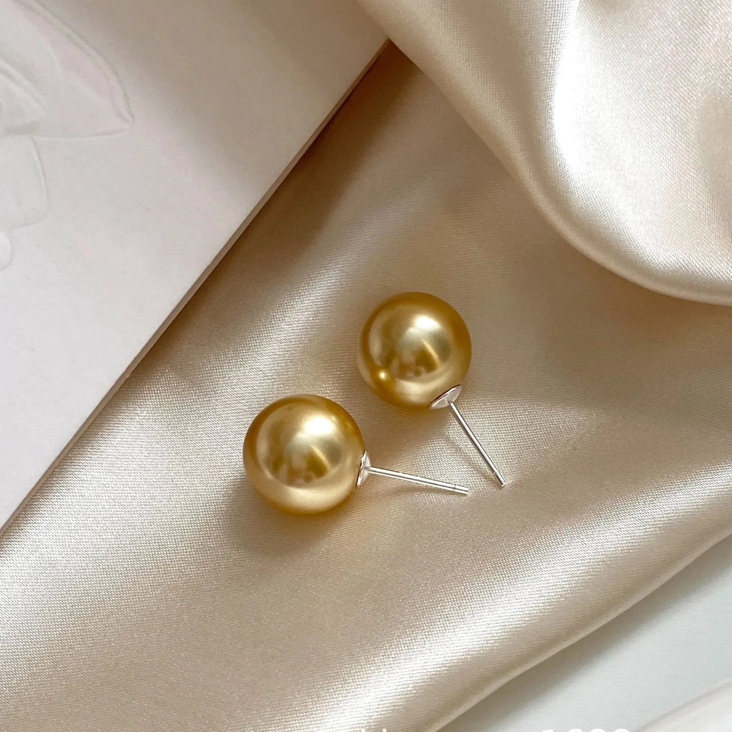 Geometric eight-point star pearl stud earrings in silver with cultured pearls, showing post-and-clasp fastening