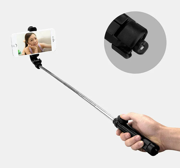 Black aluminium phone tripod stand with extended legs and a Bluetooth remote, holding an iPhone.