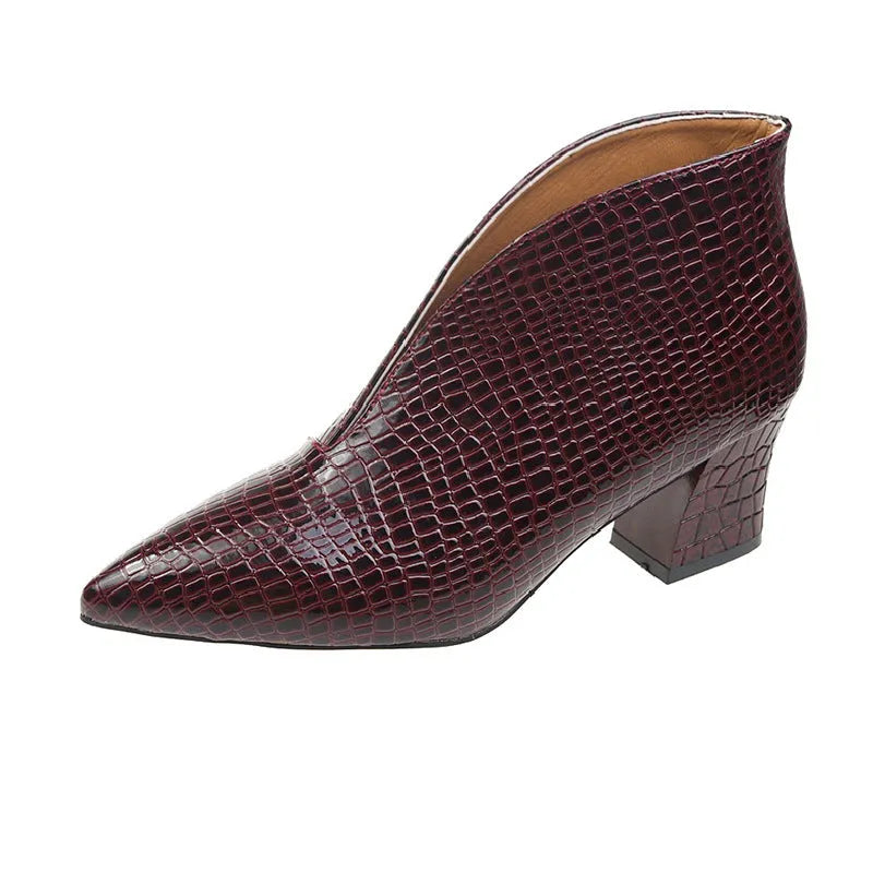 Women's black V cut Martin boots with a pointed embossed toe and a chunky heel.