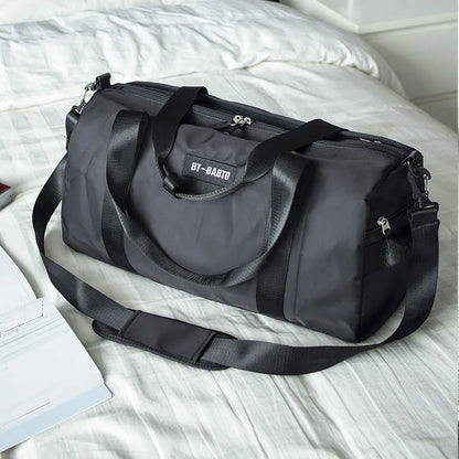 Beige casual sports bag with letter pattern and contrast colour details.