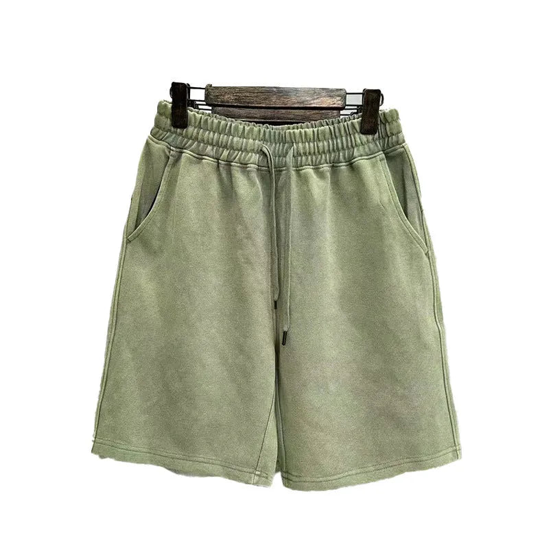 Man wearing loose-fit, straight-leg distressed cotton shorts in a solid colour