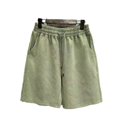 Man wearing loose-fit, straight-leg distressed cotton shorts in a solid colour