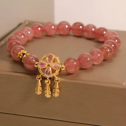 Women's strawberry quartz crystal bracelet with a four-leaf clover dream catcher pendant.