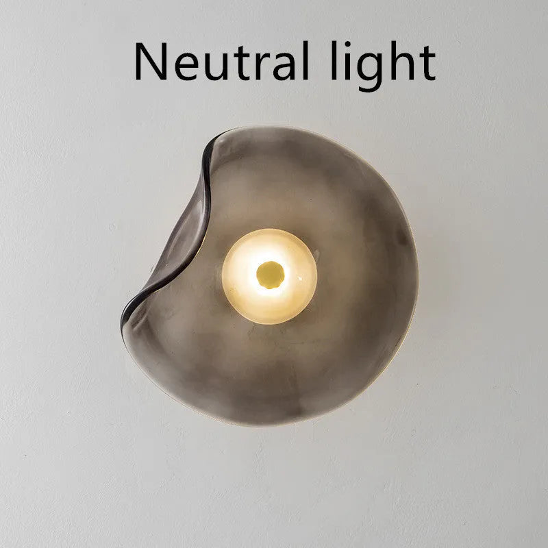 Round glass wall lamp mounted beside bed in cognac colour with 220V operation for bedside lighting