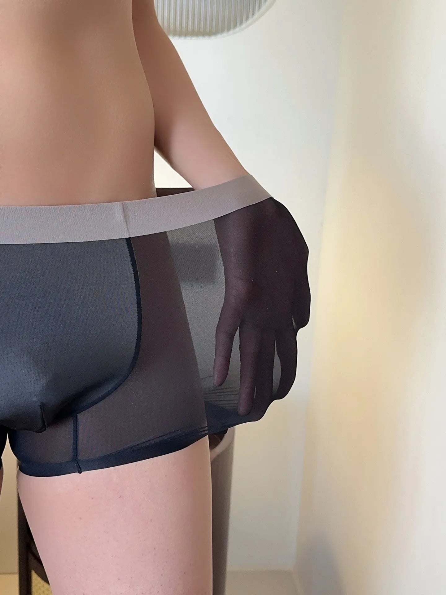 Ultra-thin seamless men's boxers in black with a honeycomb crotch design, laid flat.