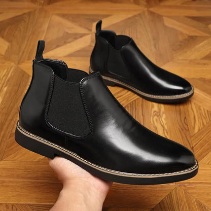 A pair of formal black leather pointed-toe boots with a square heel and rubber sole