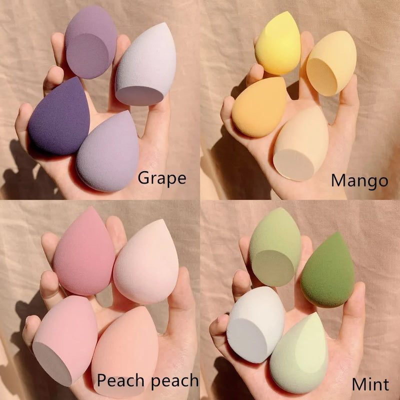 Synthetic sponge makeup egg box with four individual pieces in Grape, Mango, Mint, or Peach peach, each measuring approximately 6 cm in length, width, and height for beauty application and storage.
