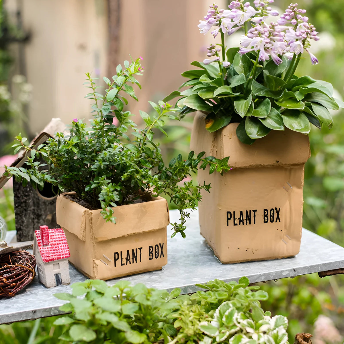 A grey cement flowerpot with a folded paper box design, shown with a drainage hole in its base.