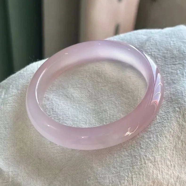 Natural agate wide tire bracelet in pink, showing polished stone beads on a wrist.