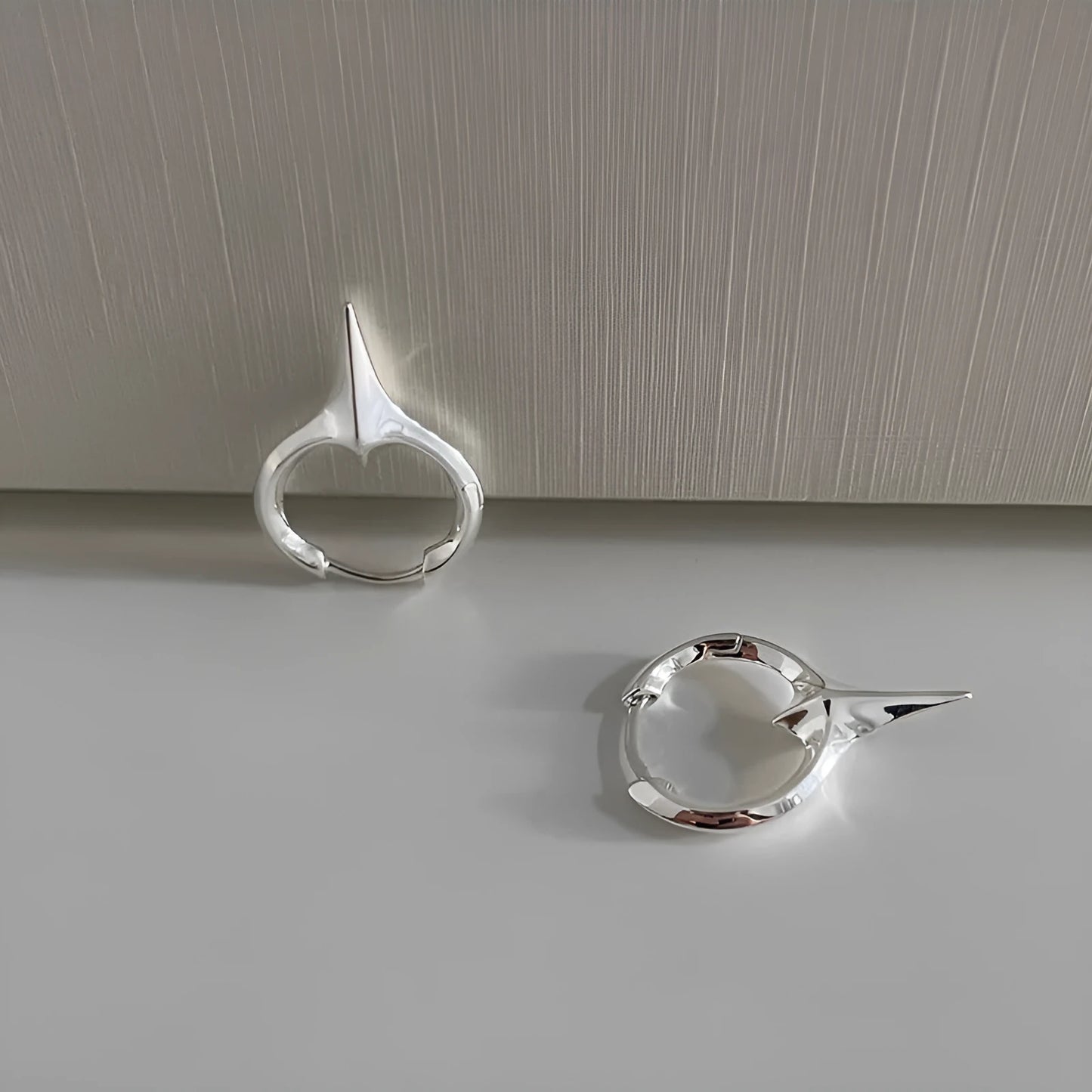 A pair of platinum-coloured star-shaped geometric ear clips for women with a copper white gold plated finish.