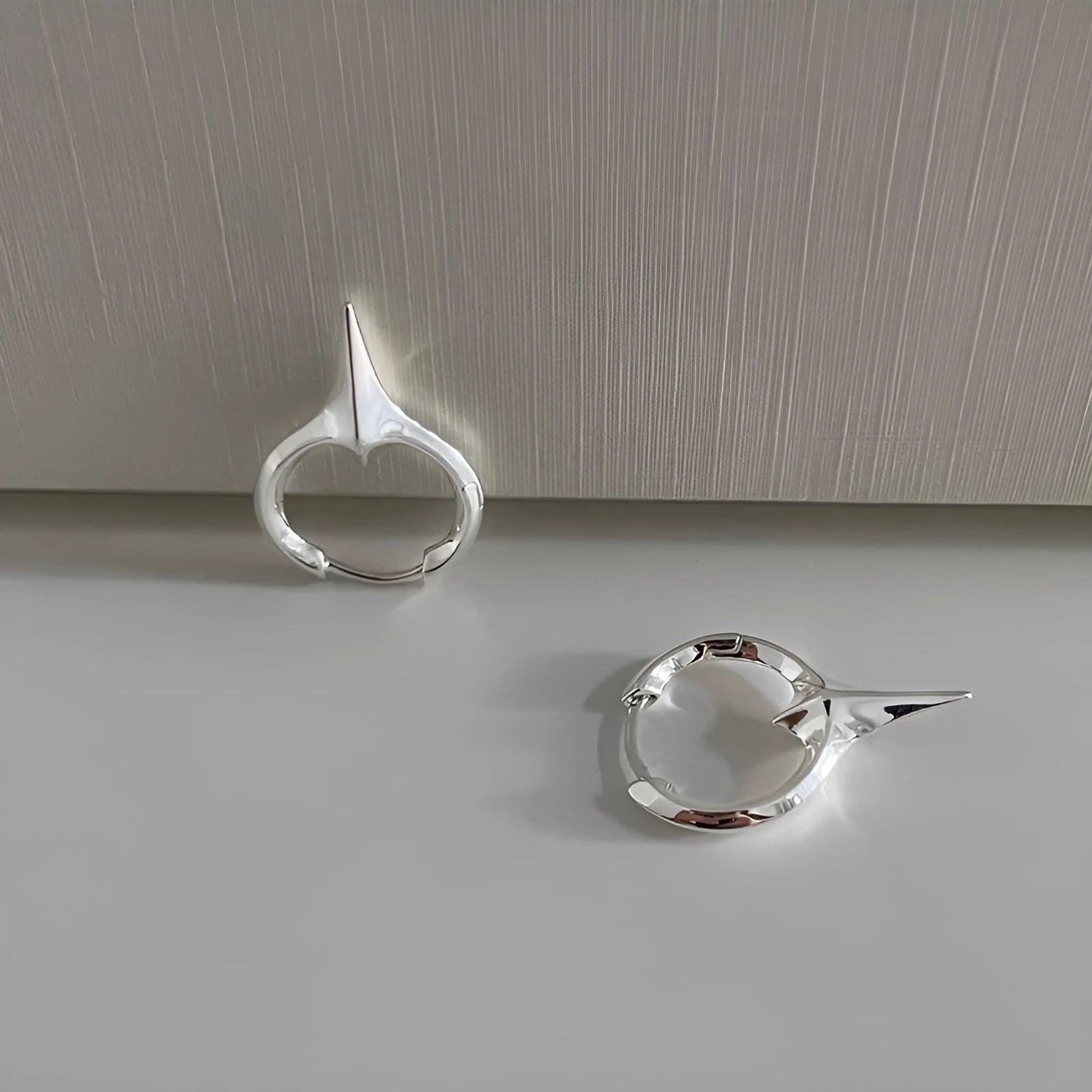 A pair of platinum-coloured star-shaped geometric ear clips for women with a copper white gold plated finish.