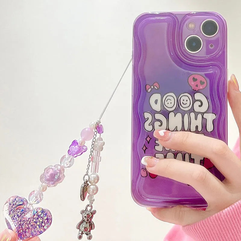 Phone case with wrist chain attachment for Apple iPhone 14 models, purple graffiti and love pendant design, made from flexible TPU with bumper edge protection featuring fade-resistant IMD printing process and anti-drop functionality