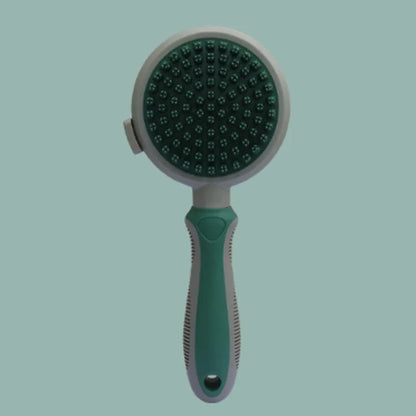 Green and pink dual-sided pet brush showing slicker pins and silicone massage nubs on a wooden table.