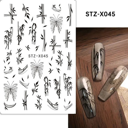 Assortment of black and silver nail sticker designs including cartoon and French tip patterns on a plastic sheet.