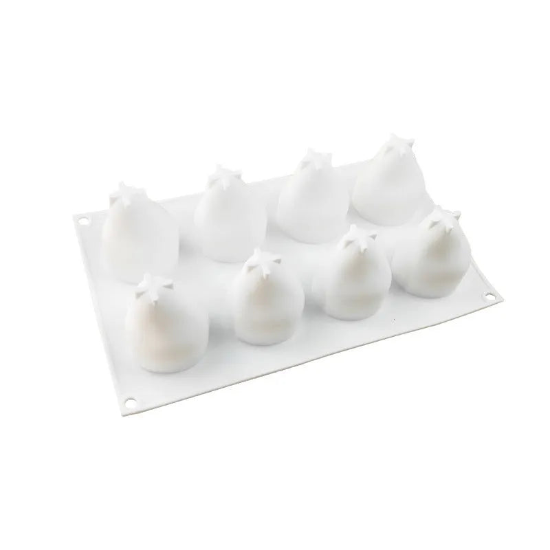 Flexible blue silicone baking mould with six cavities shaped like pineapples and pine cones on a kitchen counter.