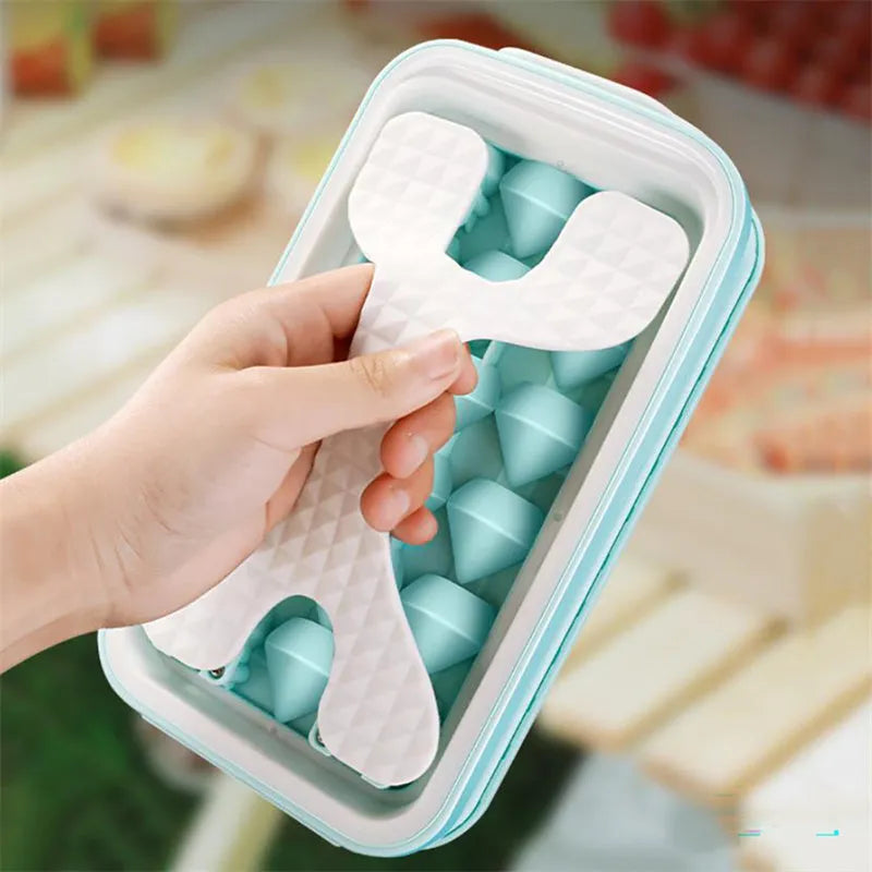Light grey silicone ice ball mould and water bottle with lid on a kitchen counter.