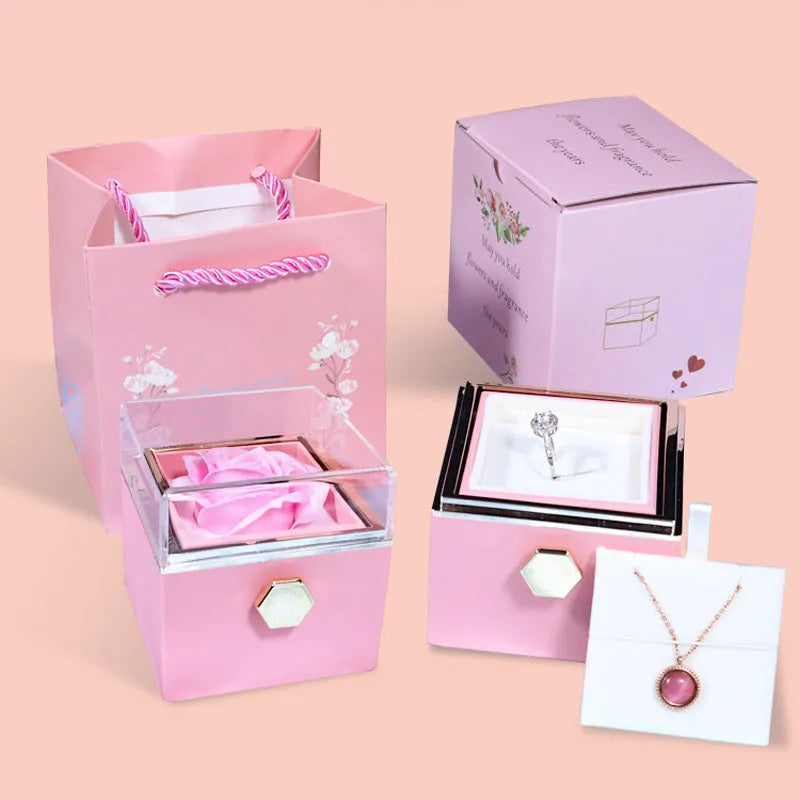 Rotating rose jewellery gift box with a preserved red rose under a clear acrylic dome, showing the interior rotating drawer.