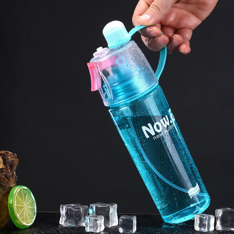 Green mist spray water bottle with clear volume scale and leakproof lid on a wooden table.